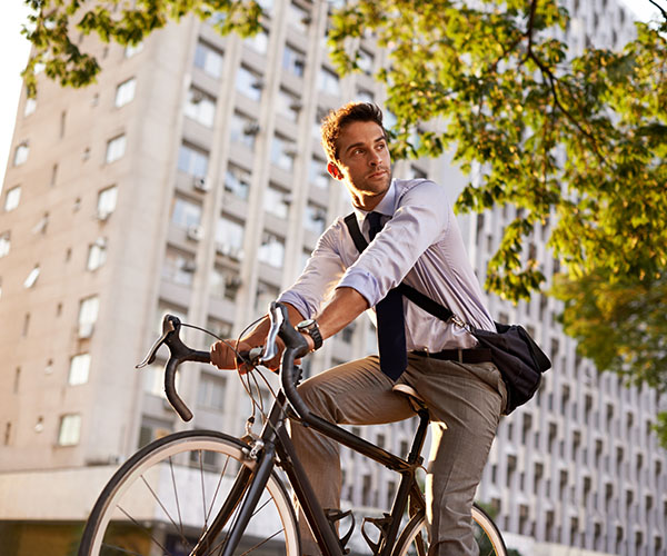 Mann fährt mit dem Rennrad zur Arbeit