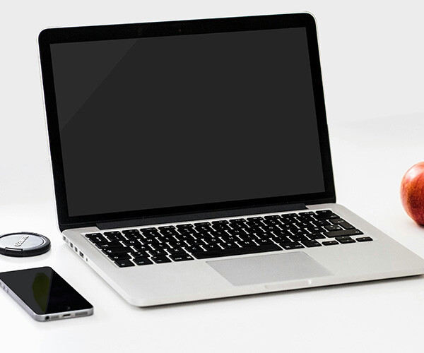 Laptop und Smartphone auf einem aufgeräumten Schreibtisch