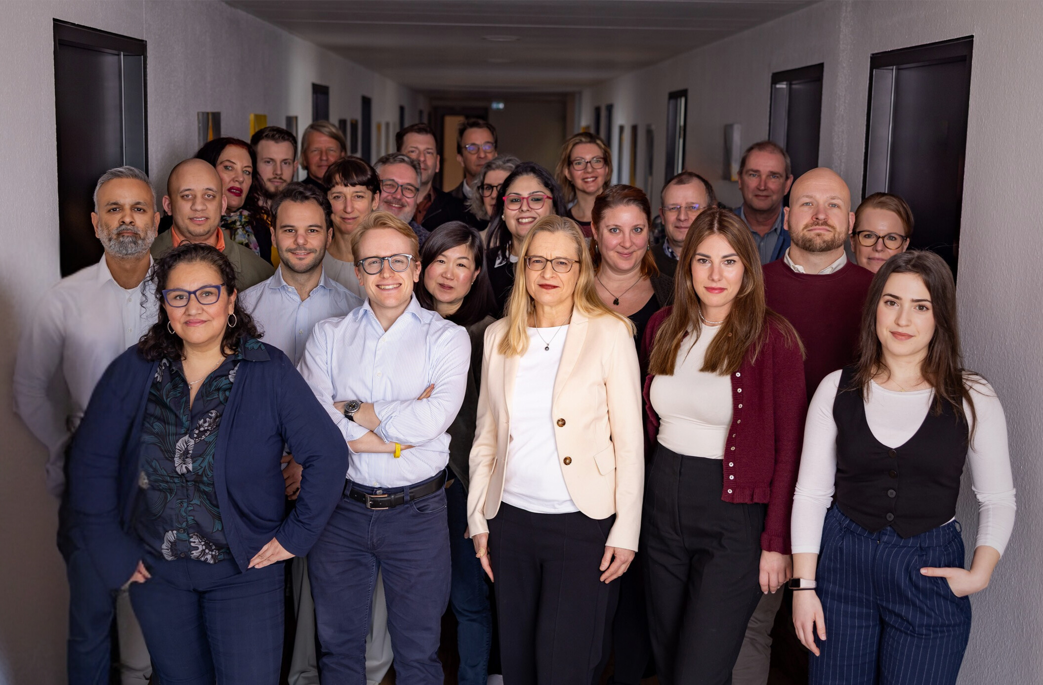Group photo of the Kunststoff Information team in the office corridor