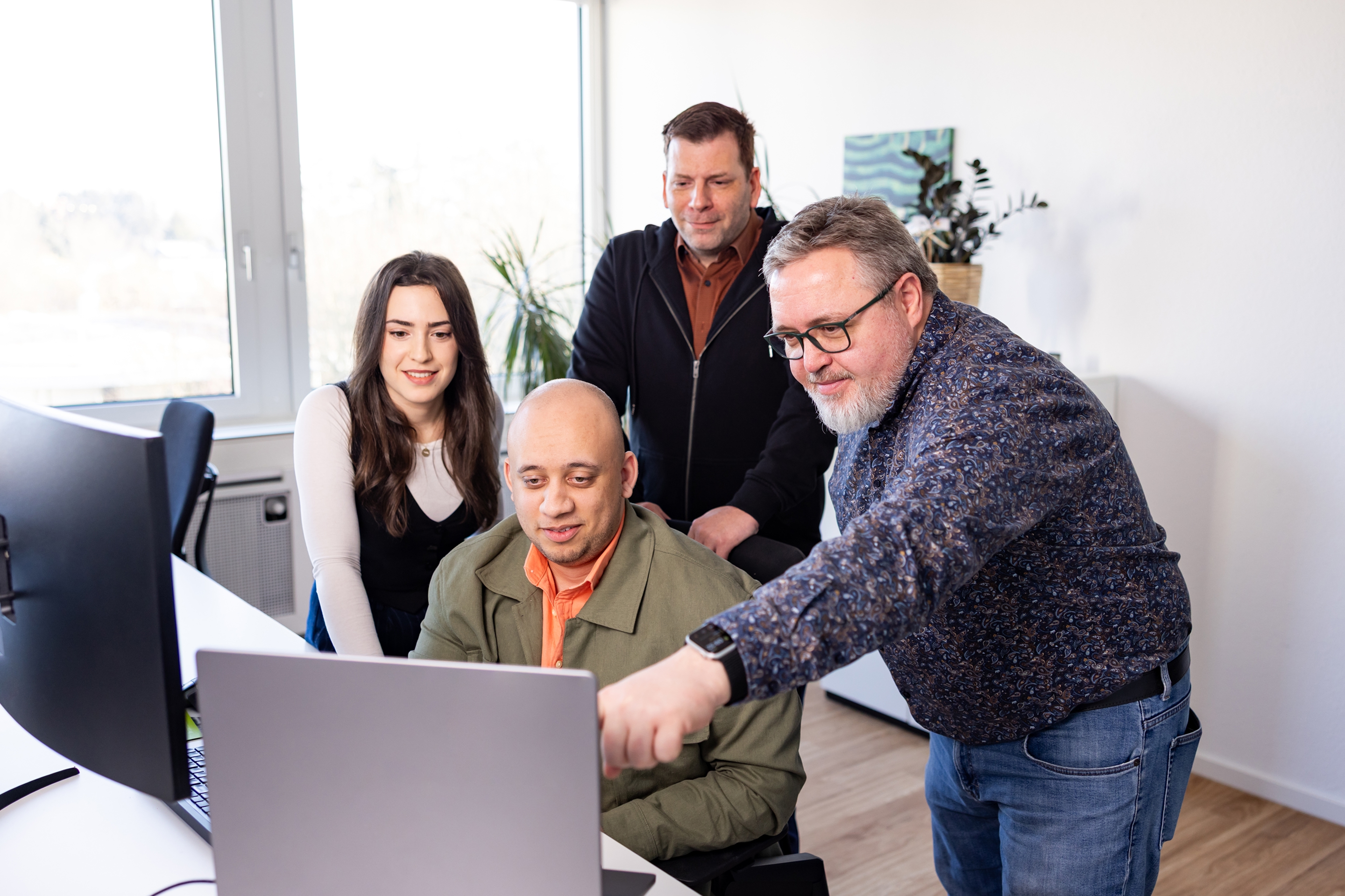 Four colleagues looking at a screen together